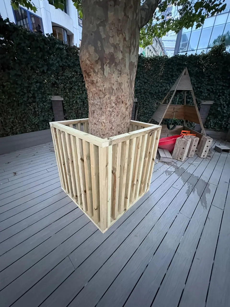 Timber planter surround on composite decking in a courtyard