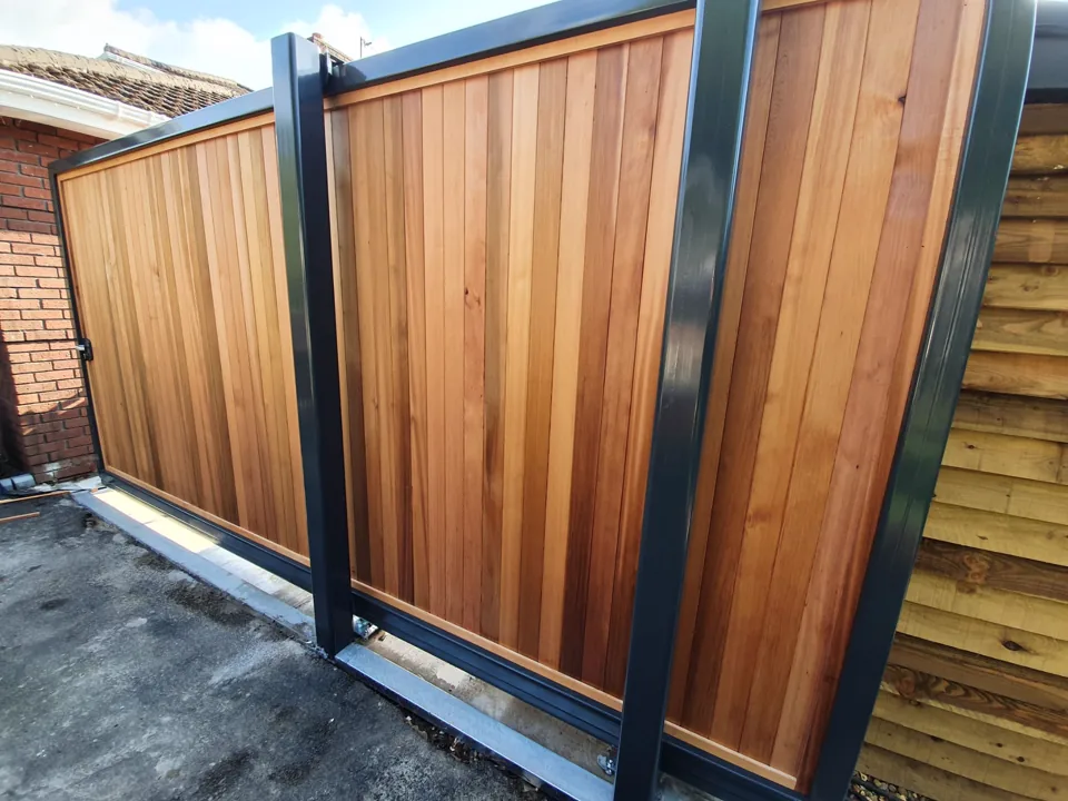Cedar-boarded sliding gate in an anthracite steel frame