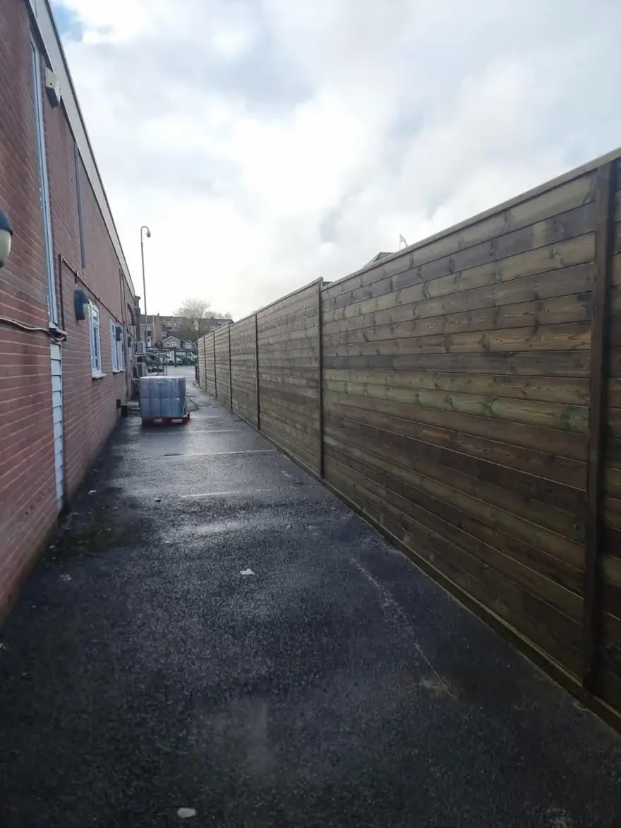 Long timber acoustic fence along a service path