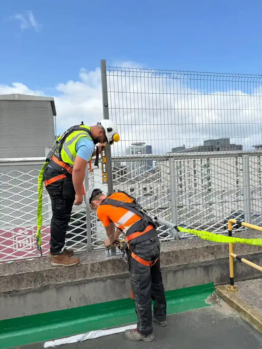 Kingsley operatives installing safety fencing at height on a Cardiff rooftop